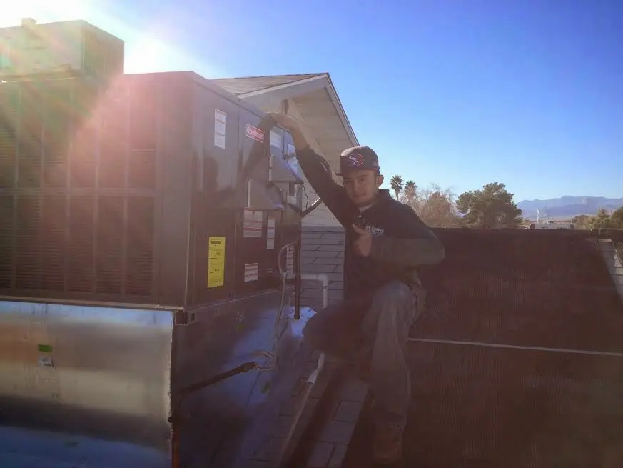 HVAC technician performing Boiler Repair on a rooftop unit in Ayden